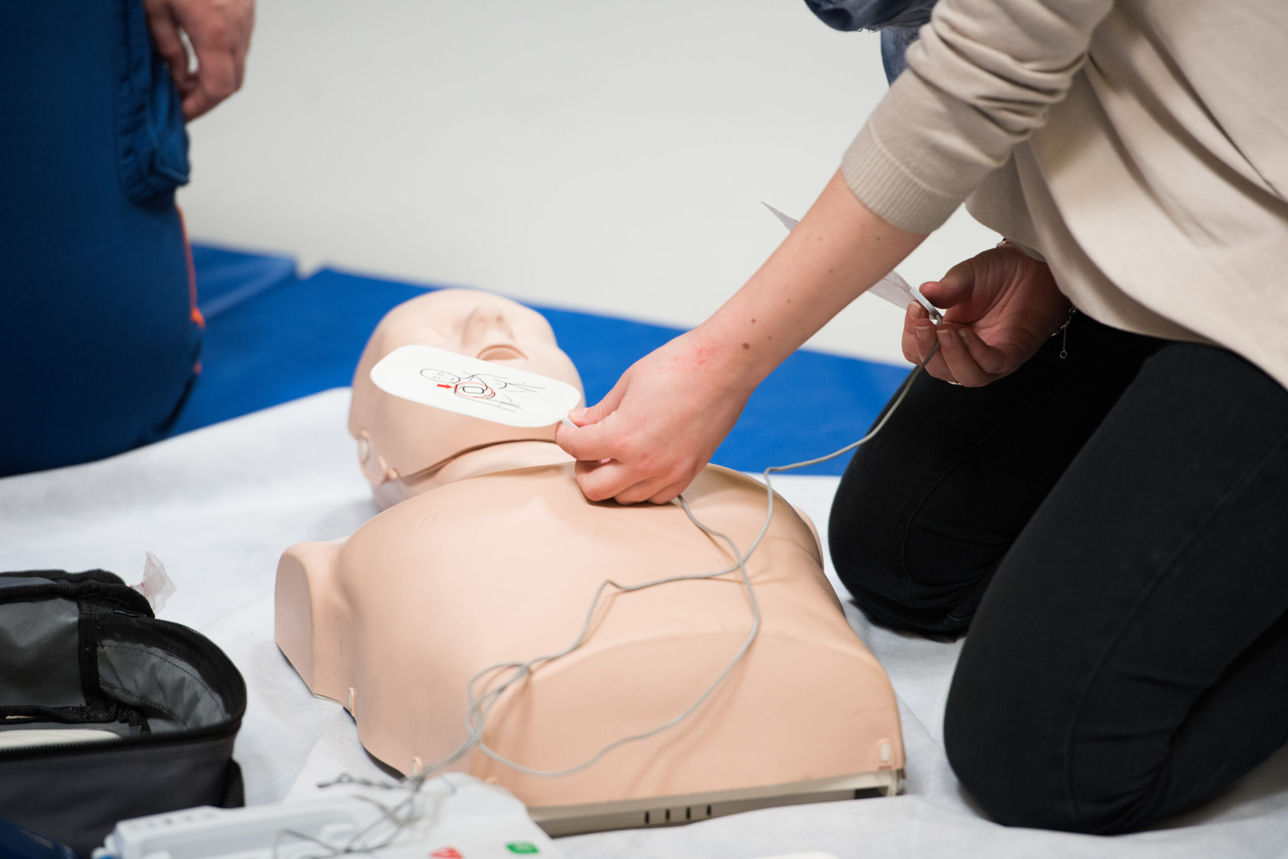 Un salarié applique les électrodes d’un défibrillateur automatisé externe sur un mannequin lors d’un exercice de formation SST ING2A.